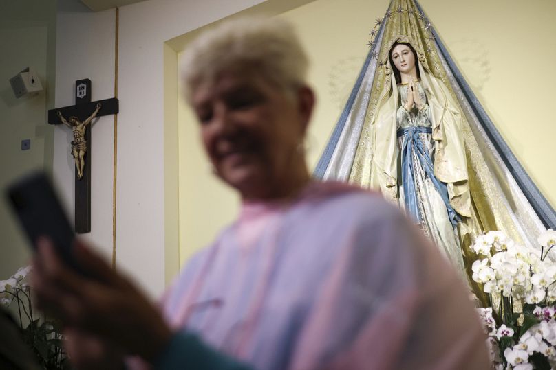 Ein Pilger macht ein Selbstporträt vor der Statue der Jungfrau Maria in der St. James Kirche in Medjugorje, Bosnien, Donnerstag, 19. September 2024.