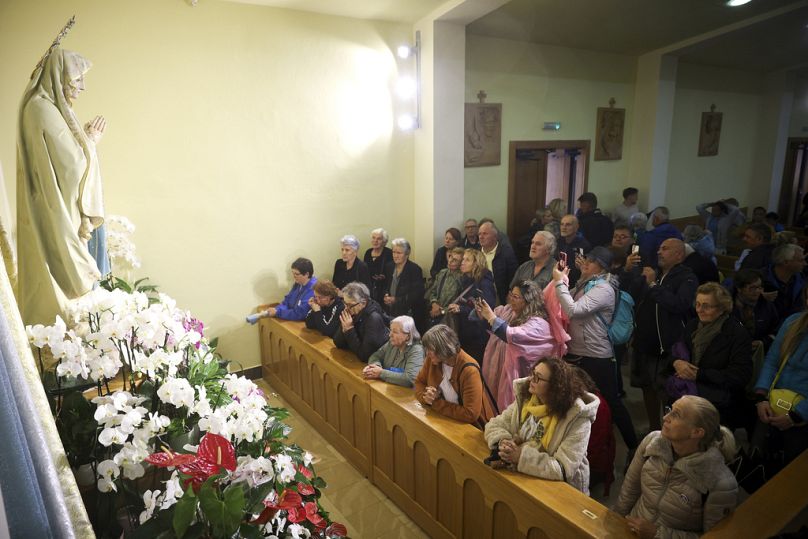 Pilger beten neben der Statue der Jungfrau Maria in der St. James Kirche in Medjugorje, Bosnien, Donnerstag, 19. September 2024. 