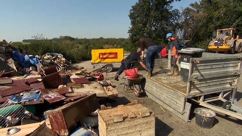 Des employés municipaux évacuent des objets détruits par les inondations à Untergrafendorf en Autriche