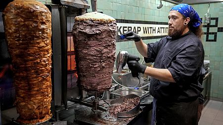  Turkish cook prepares the doner kebabs, in Berlin, Germany, Wednesday, Sept. 18, 2024. 