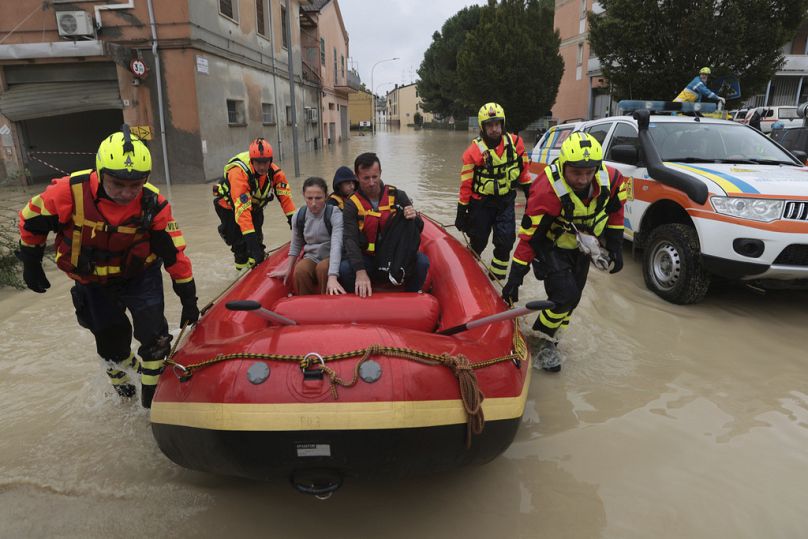 I vigili del fuoco utilizzano un gommone per evacuare i civili dopo un'alluvione a Faenza, in Emilia Romagna