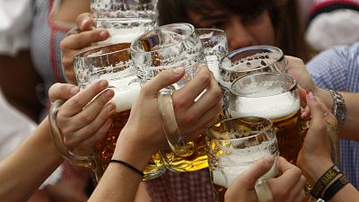 Visitors lift their beer mugs in the Hofbraeuhaus-tent after the opening of the famous Bavarian "Oktoberfest" beer festival in a beer tent in Munich.