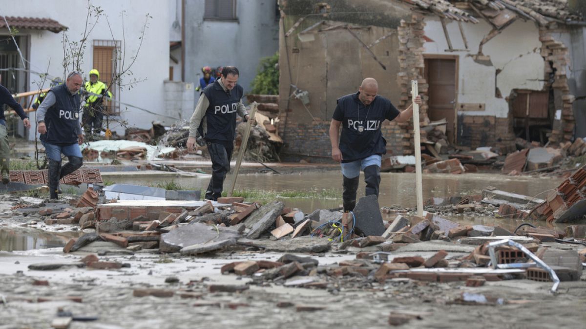 Police officers make their way through a flooded area after persistent rains and floods have been hitting the Emilia Romagna region, in Traversara, Italy, Friday, Sept. 20, 20