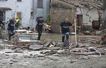 Police officers make their way through a flooded area after persistent rains and floods have been hitting the Emilia Romagna region, in Traversara, Italy, Friday, Sept. 20, 20