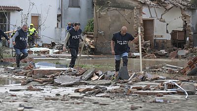 Police officers make their way through a flooded area after persistent rains and floods have been hitting the Emilia Romagna region, in Traversara, Italy, Friday, Sept. 20, 20