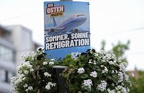 An election campaign poster of the far-right Alternative for Germany, AfD, promising "summer, sun, remigration" and depicting a plane with the logo "Deportation-Hansa." is dis