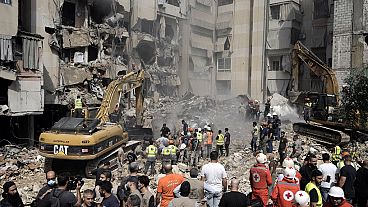 Emergency workers use excavators to clear the rubble at the site of Friday's Israeli strike in Beirut's southern suburbs, Saturday, Sept. 21, 2024. 