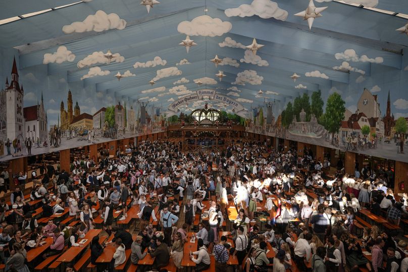 Visitors wait in the tent of the Hacker-Pschorr brewery the start of the 189th 'Oktoberfest' beer festival in Munich, Germany, Saturday, Sept. 21, 2024.