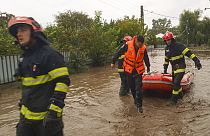 Rescuers drag a boat on a flooded street in Pechea, Romania, Saturday, Sept. 14, 2024 after torrential rainstorms left scores of people stranded in flooded areas.