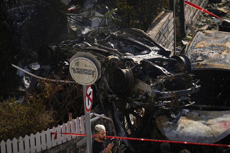 Um homem olha para o local atingido por um foguete disparado do Líbano, em Kiryat Bialik, no norte de Israel, no domingo, 22 de setembro de 2024.