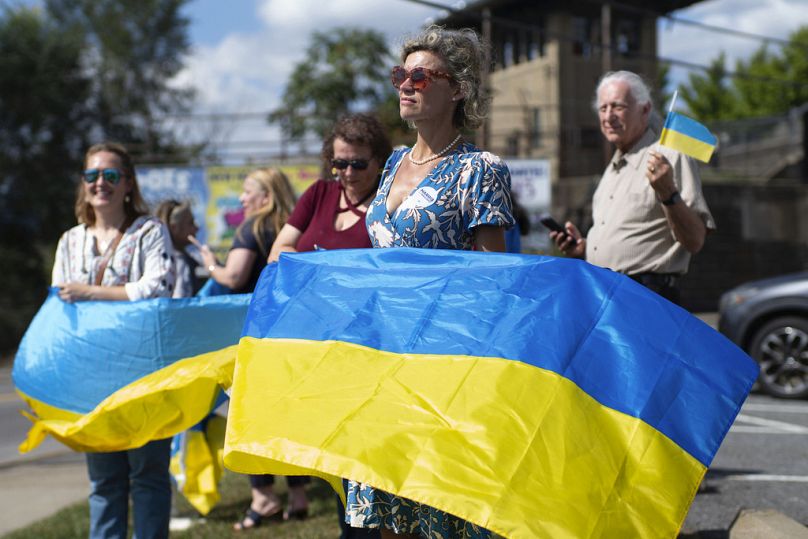 Kristina Ramanauskas agita uma bandeira ucraniana antes da chegada da comitiva do presidente da Ucrânia, Volodymyr Zelenskyy, à fábrica de munições 