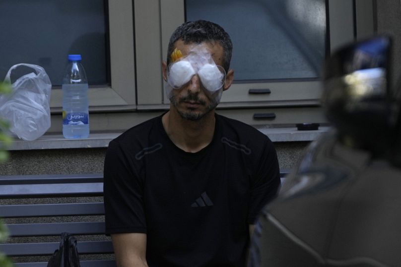 A man who was injured in the explosion of one of the handheld devices, sits outside the Eye Specialist hospital, in Beirut, Lebanon, Friday, Sept. 20, 2024