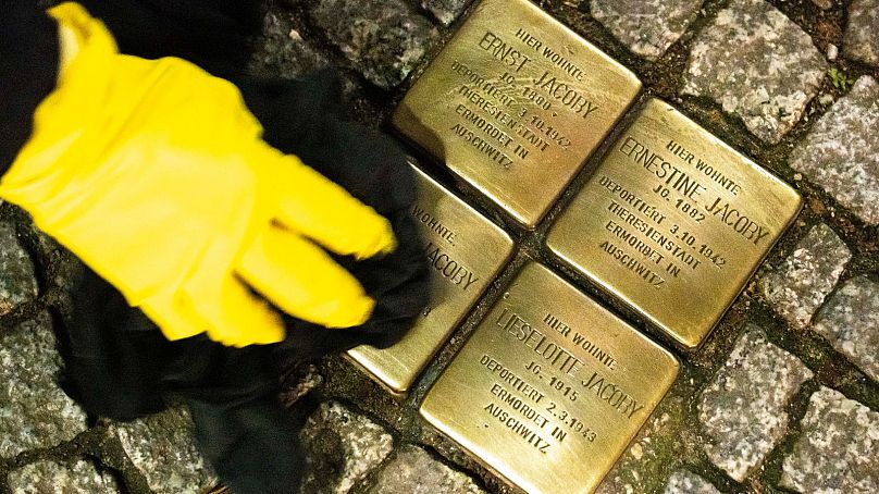 A man polishes Stolpersteine on the eve of the 85th anniversary of the Nazis' anti-Jewish pogrom in 1938, in Berlin - 8 November 2023