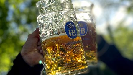 La gente brinda con sus jarras de cerveza en la cervecería "Taxisgarten" de Múnich.