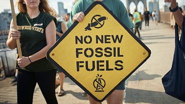 Protestors carry placards as they cross the Brooklyn Bridge during a Youth Climate Strike march to demand an end to the era of fossil fuels.