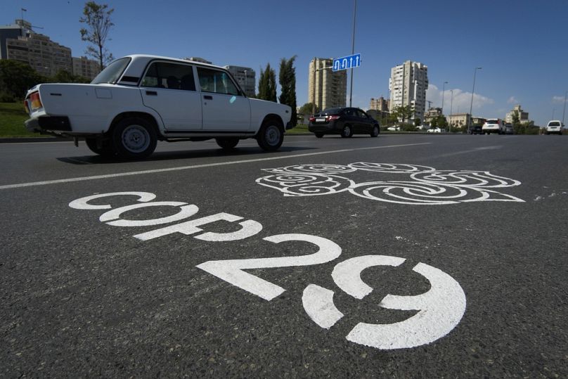 The logo for the COP29 United Nations Climate Change Conference is painted on a road in Baku, Azerbaijan.