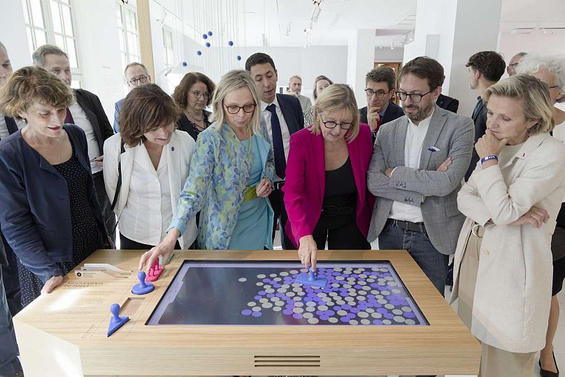 Director of the Institut Henri Poincaré Sylvie Benzoni (in blue) and others demonstrating the crowd movement simulation at the Maison Poincaré.