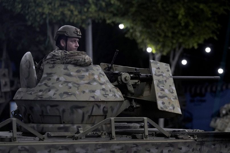 A Lebanese soldier sits on the top of an armoured personnel carrier at the site of an Israeli airstrike in Beirut's southern suburb, Monday, Sept. 23, 2024.