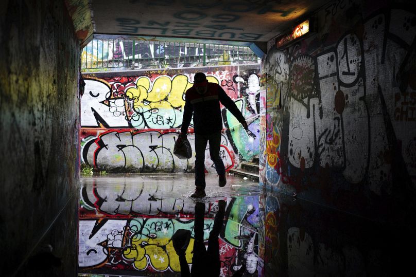 A person shelters from the rain in a flooded underpass by Lawrence Hill Roundabout, Bristol, England, Monday Sept. 23, 2024.