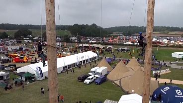 Two men are climbing up a pole.