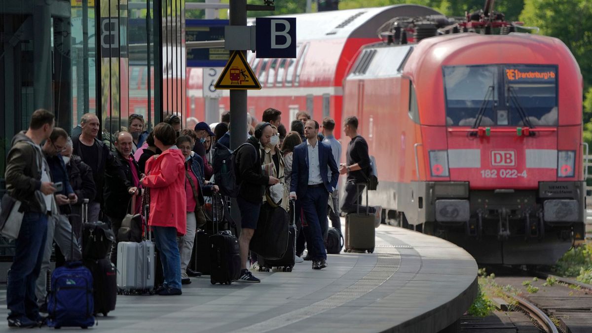 Bir tren Berlin, Almanya'daki ana tren istasyonundan ayrılırken yolcular platformda bekliyor, 1 Haziran 2022. 