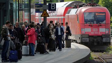 Travellers wait on a platform as a train leaves the main train station in Berlin, Germany, 1 June 2022. 