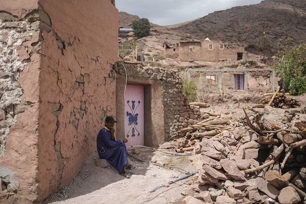 Un homme est assis à l'extérieur d'une maison qui a été endommagée lors du tremblement de terre de 2023