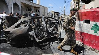 Un soldato dell'esercito libanese passa davanti a un'auto colpita da un attacco israeliano nella città portuale meridionale di Sidone, in Libano, mercoledì 21 agosto 2024. (Foto AP/Mohammad Zaata