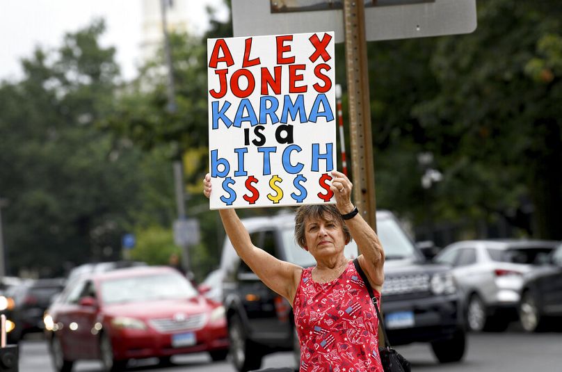 Middlebury'li Karen Rotella, Connecticut'taki Waterbury Yüksek Mahkemesi dışında komplo teorisyeni Alex Jones'u protesto ediyor.