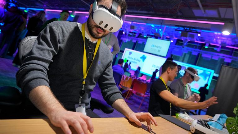 A visitor tries out a Meta Quest 3 headset to for a mixed reality piano playing experience at the Meta AI Day in London, Tuesday, April 9, 2024. 
