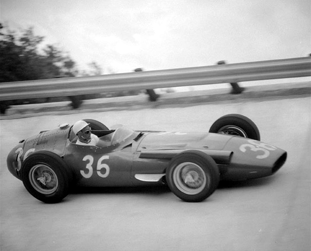 Le Britannique Stirling Moss conduit sa Maserati dans une courbe du circuit de Monza, en Italie, le 2 septembre 1956, lors du Grand Prix d'Europe de 300 miles.