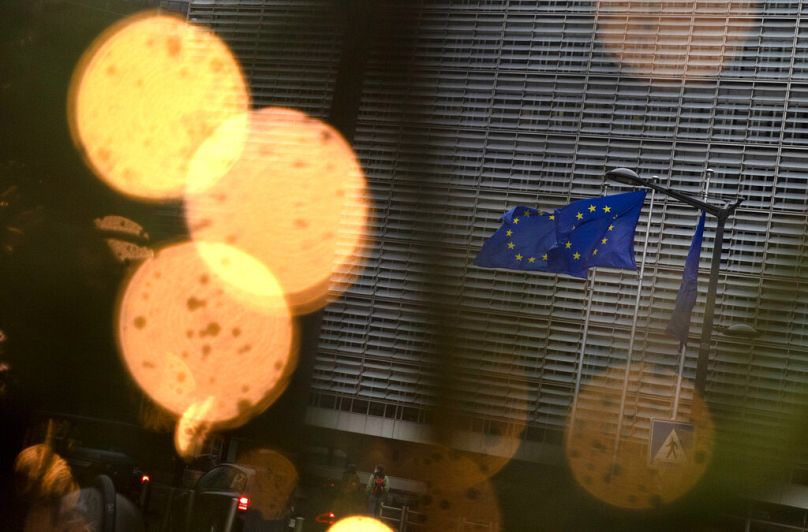 European Union flags flutter in the wind amongst Christmas decorations outside of EU headquarters in Brussels, December 2020