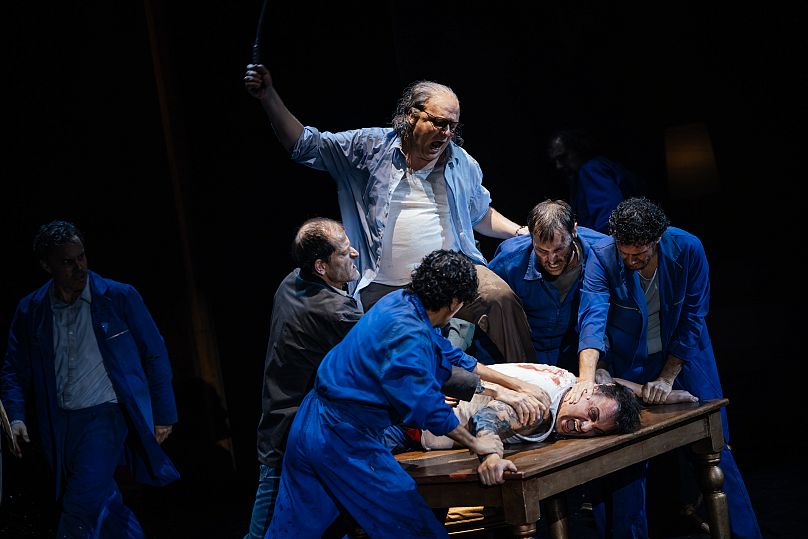 Tenor Pavel Cernoch, who portrays Sergei, is dramatically restrained on a table. 