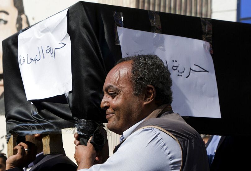 صحفيون يحملون نعشًا رمزيًا يمثل ما يقولون إنه "حرية الصحافة" في نقابة الصحفيين في القاهرة بمصر