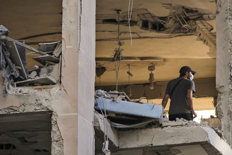 Bir bölge sakini, Beyrut'un güney banliyölerinde İsrail hava saldırısında vurulan bir daireyi kontrol ediyor, 25 Eylül 2024.