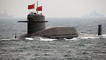 Un sottomarino a propulsione nucleare della Marina cinese naviga durante una rassegna internazionale della flotta nelle acque al largo di Qingdao