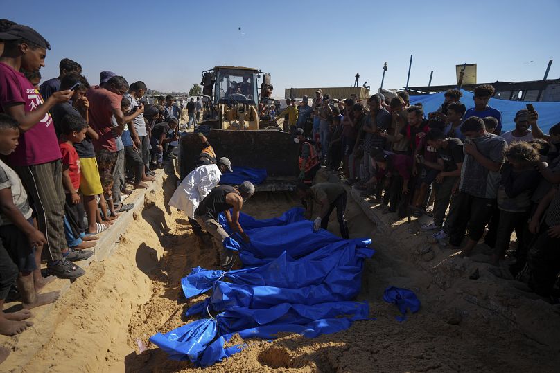 أشخاص يدفنون جثامين الفلسطينيين الذين أخذهم الجيش الإسرائيلي خلال عملياته في غزة وأعادهم هذا الأسبوع، في خان يونس، قطاع غزة، الخميس، 26 سبتمبر/أيلول 2024