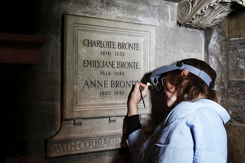 Conservator Lucy Ackland adds the finishing touches to the memorial to Charlotte, Emily and Anne Bronte at Poets' Corner in Westminster Abbey in London - 26 September 2024