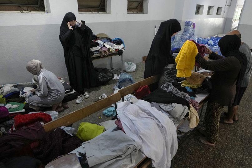 Volunteers distribute clothes to displaced women at a school in Beirut, Thursday, Sept. 26, 2024. 