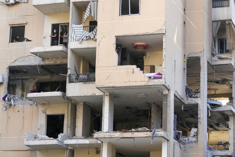 Des habitants et des sauveteurs vérifient un bâtiment touché par une frappe aérienne israélienne dans la banlieue sud de Beyrouth, le 26 septembre 2024.