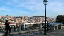 A woman takes a snapshot of the view from Sao Pedro de Alcantara Garden in Lisbon Dec. 22, 2008. 