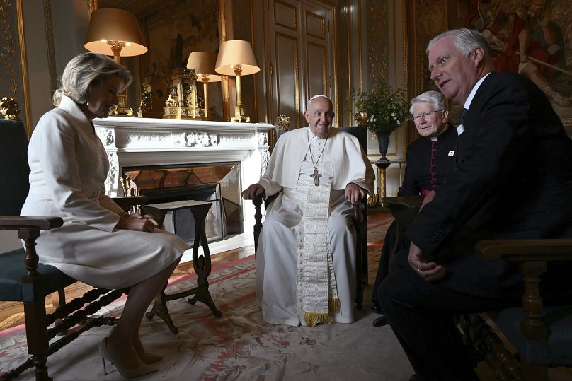 Pope Francis, center, talks to King Philippe of Belgium, right, and Queen Mathilde at the Castle of Laeken, Belgium, Friday, Sept. 26, 2024