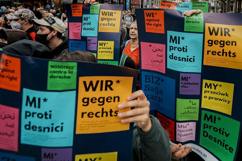 People hold multilingual banners that read "We're against the right wing," before the final electoral rally of the Freedom Party in Vienna, September 27, 2024