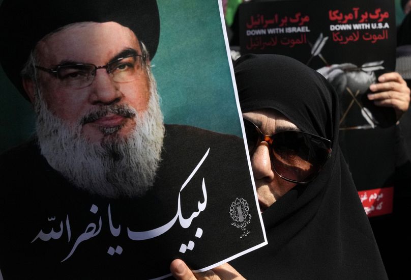 Un fidèle iranien brandit une affiche du chef du Hezbollah, Hassan Nasrallah, sur laquelle on peut lire en arabe : « A votre service Nasrallah », à Téhéran, le 27.09.2024 