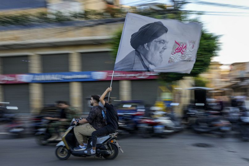 Hezbollah supporters carry a flag depicting Hezbollah leader Hassan Nasrallah, September 25th 2024