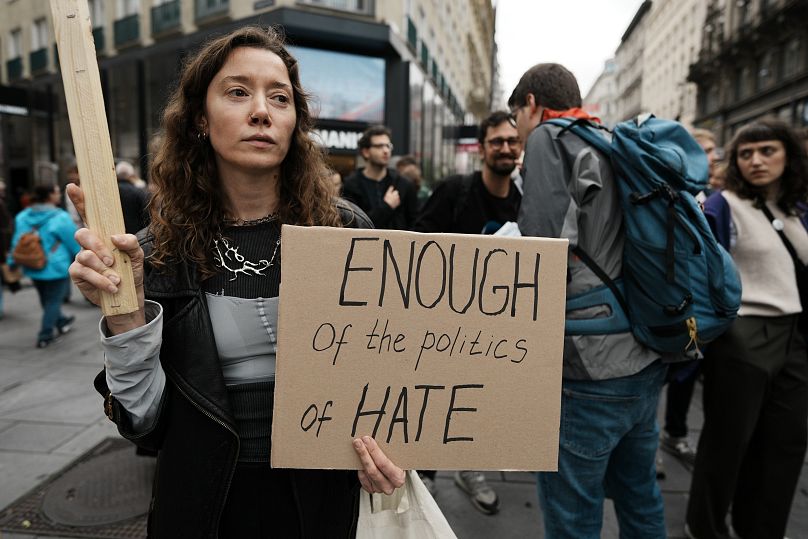 Um manifestante segura uma faixa durante um protesto contra a direita em Viena, a 27 de setembro de 2024