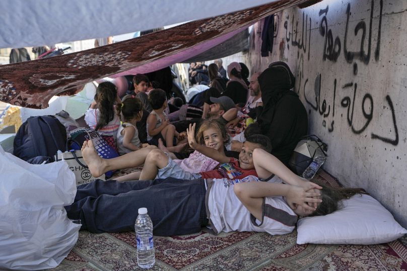 Children with their families lie on the ground in Beirut's Martyrs' square after fleeing the Israeli airstrikes in Beirut's southern suburbs, Saturday, Sept. 28, 2024.