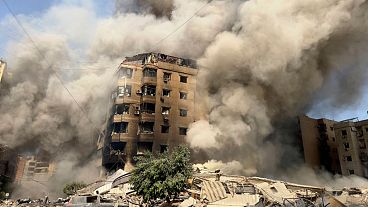 Smoke rises as a building collapses in Beirut's southern suburbs