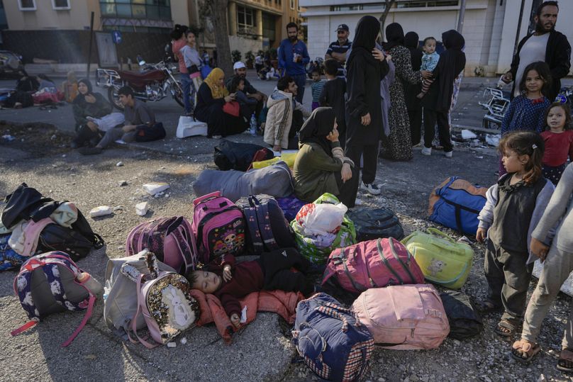 Families gather in Martyrs' square after fleeing the Israeli airstrikes in Beirut's southern suburbs, Saturday, Sept. 28, 2024. 