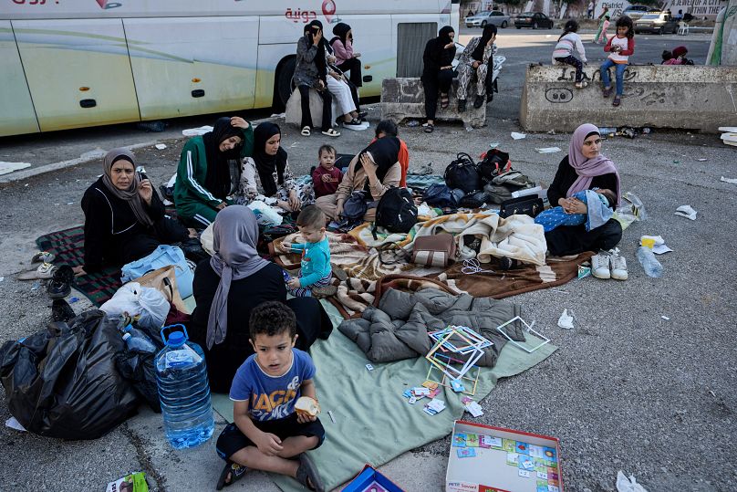 عائلات تجلس على الأرض في ساحة الشهداء بعد فرارهم من الغارات الجوية الإسرائيلية في الضاحية الجنوبية لبيروت، السبت 28 سبتمبر/أيلول 2024